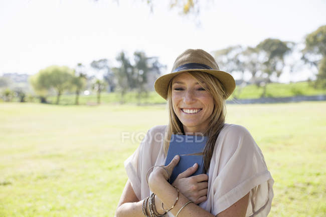 Взрослая женщина в поле, держит книгу — стоковое фото