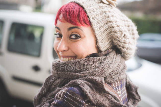 Портрет молодої жінки, яка дивиться через плече, посміхається, носіння зимового одягу — стокове фото