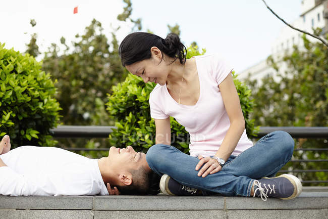 Туристична пари сидять і лежить на стіні, набережної Вайтань, Шанхай, Китай — стокове фото