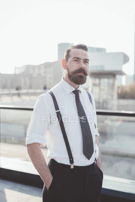 Портрет стильного бізнесмена з руками в кишенях в місті — стокове фото