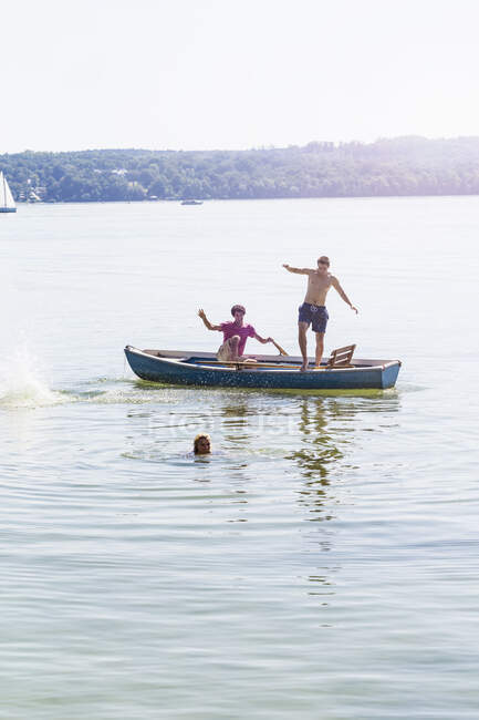 Freunde springen vom Boot und schwimmen im See, Schondorf, Ammersee, Bayern — Stockfoto