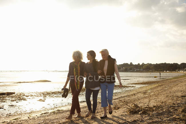 Membri della famiglia femminile che camminano sulla spiaggia — Foto stock