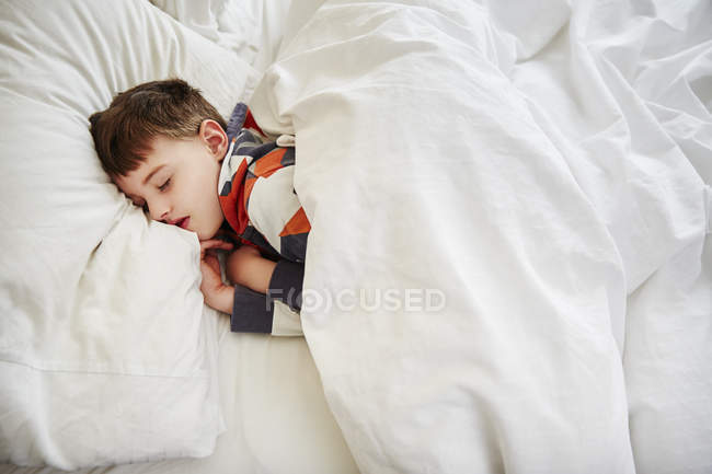 Портрет молодого хлопчика, який спить у ліжку — стокове фото