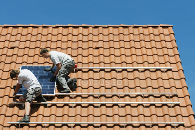 Workers installing solar panel on roof framework of house, Netherlands — Stock Photo