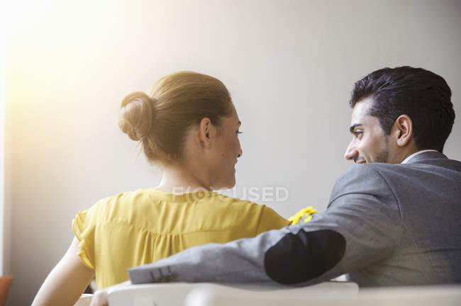 Jovem casal sentado dentro do café, visão traseira — Fotografia de Stock