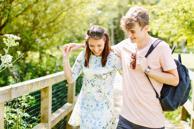 Paar läuft über Holzbrücke im Park — Stockfoto