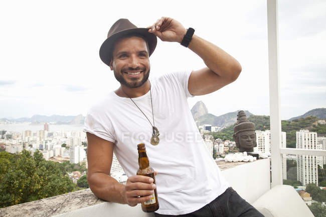 Man drinking on terrace, Sugarloaf Mountain in background, Rio, Brazil — Stock Photo