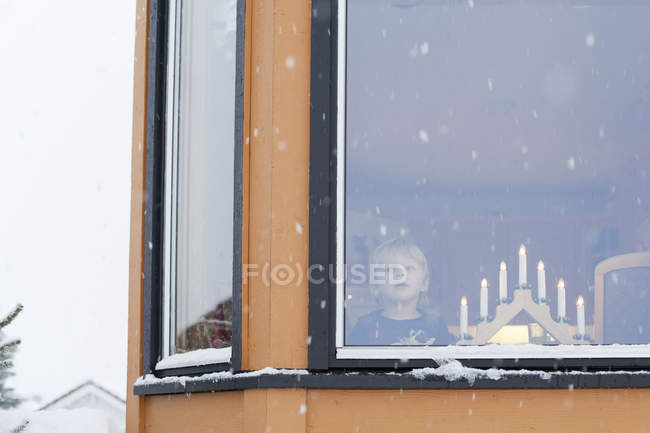 Menino esperando atrás da janela no Natal — Fotografia de Stock