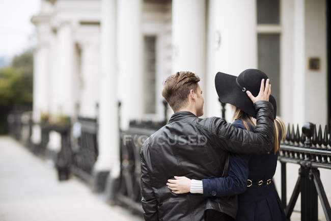 Rear view of romantic young couple strolling on street, London, England, UK — Stock Photo