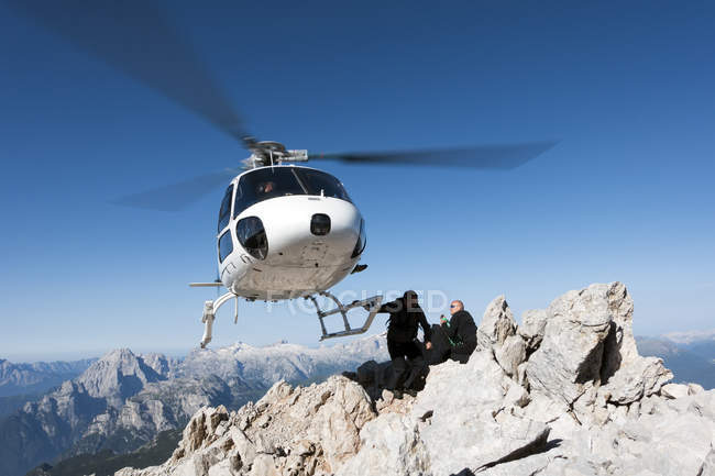 Helicopter dropping BASE jumpers on mountain, Dolomites, Italy — Stock Photo