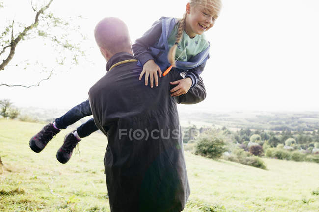 Отец носит дочь на руках — стоковое фото