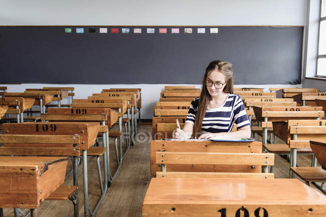 Жінка-студент, що працює в порожньому класі — стокове фото