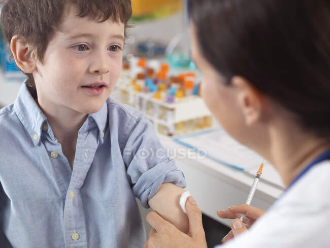 Доктор втішає молодого хлопчика в клініці — стокове фото