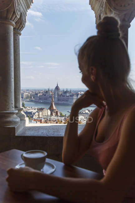 Mid adult woman sitting drinking coffee and looking at view, Budapest, Hungary — Stock Photo