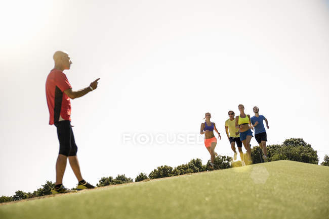 Group of people running race, running towards trainer — Stock Photo