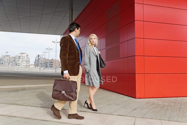 Бизнесмен и деловая женщина, гуляющие вместе, на открытом воздухе — стоковое фото