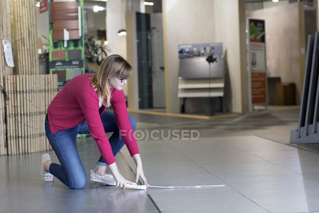 Жіночий клієнт вимірює плитку для підлоги в магазині обладнання — стокове фото