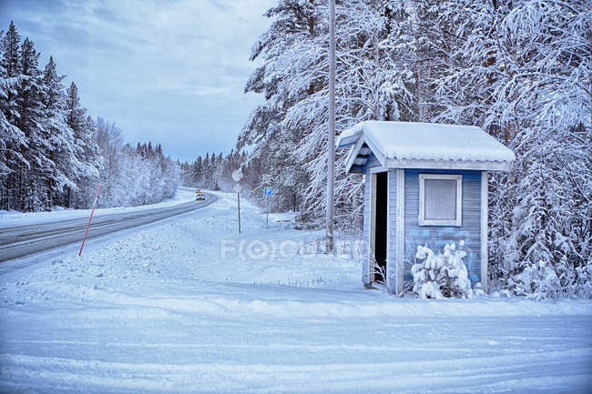 Traditionelle Bushaltestelle an der Ecke der schneebedeckten Landstraße, Hemavan, Schweden — Stockfoto