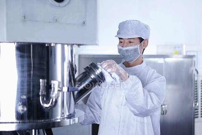 Worker wiping equipment at e-cigarettes battery factory, Guangdong, China — Stock Photo