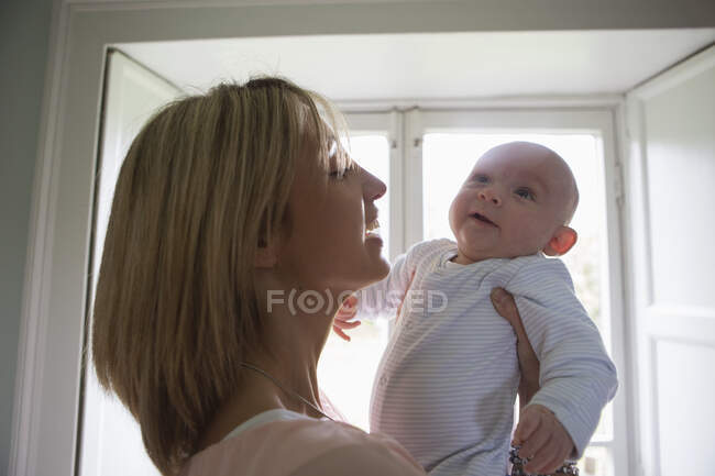 Portrait of smiling mother holding new baby boy — Stock Photo