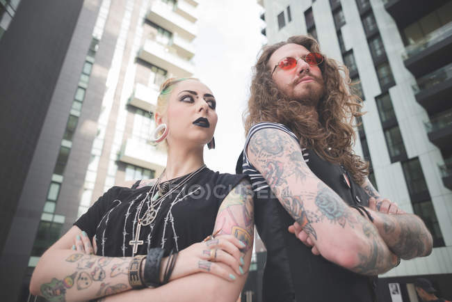 Vista de ángulo bajo de punk hippy pareja con tatuajes - foto de stock
