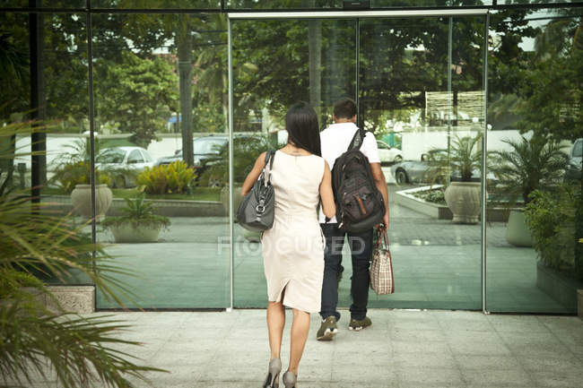 Couple adulte moyen, entrant dans le bâtiment, vue arrière — Photo de stock