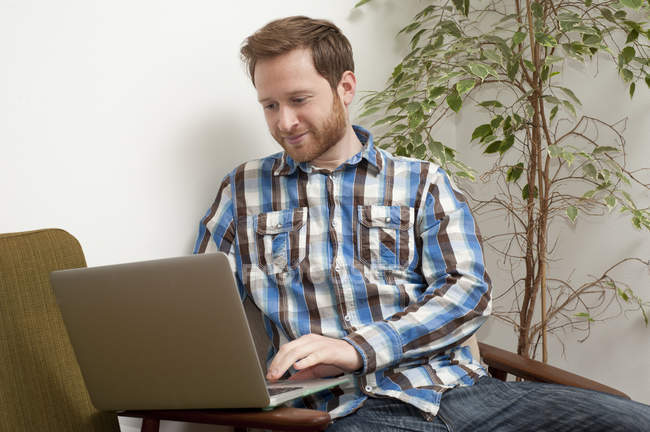 Hombre escribiendo en el ordenador portátil en la cafetería estilo - foto de stock