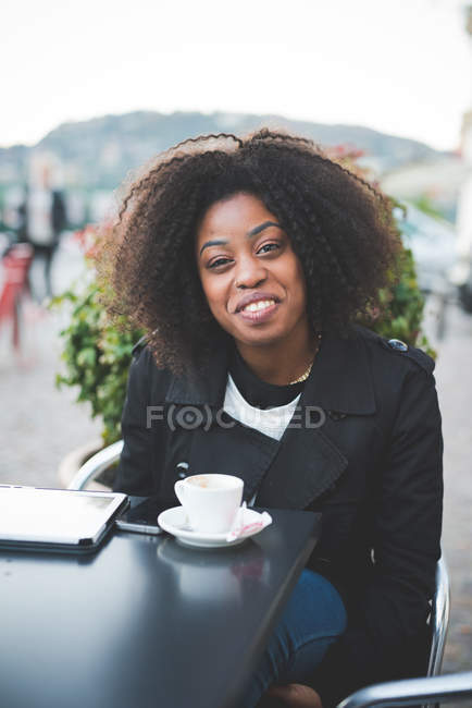Retrato de mujer joven en la mesa de café de la acera, Lago de Como, Como, Italia - foto de stock