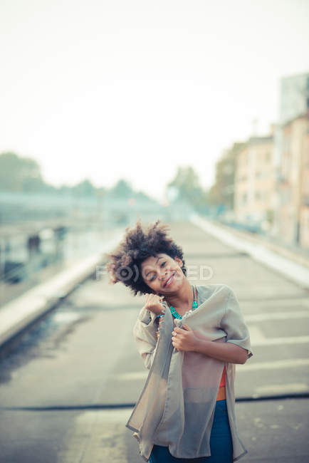 Retrato de mujer joven con la cabeza en la ciudad - foto de stock