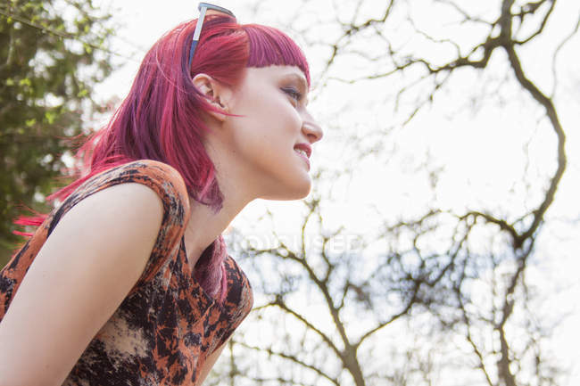Porträt einer lächelnden jungen Frau mit rosa Haaren — Stockfoto