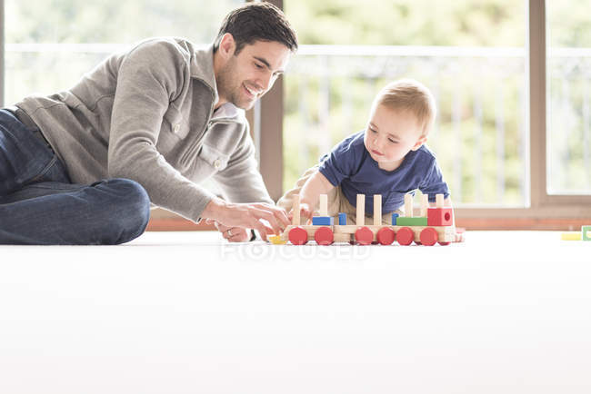 Padre e hijo jugando juntos en casa - foto de stock