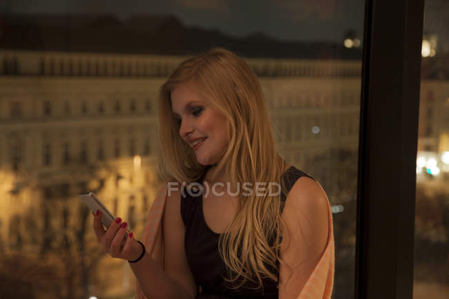 Junge Frau mit Smartphone im Hotelzimmer, Wien, Österreich — Stockfoto