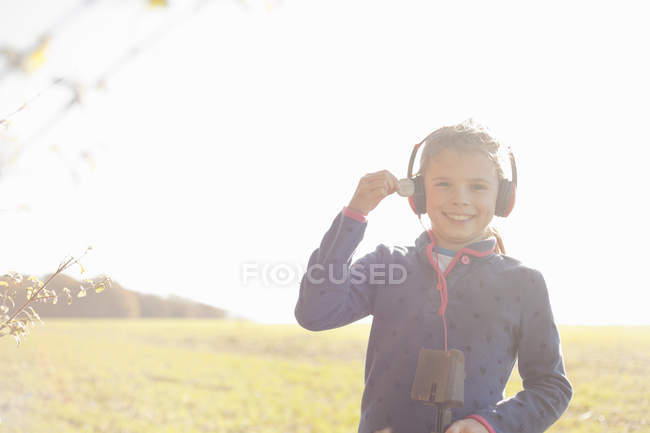 Portrait of girl metal detecting in field holding up silver coin — Stock Photo