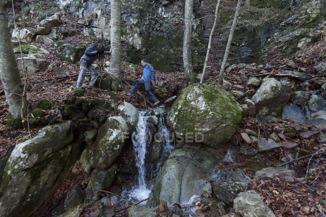 Hikers crossing stream, Montseny, Barcelona, Catalunha, Espanha — Fotografia de Stock