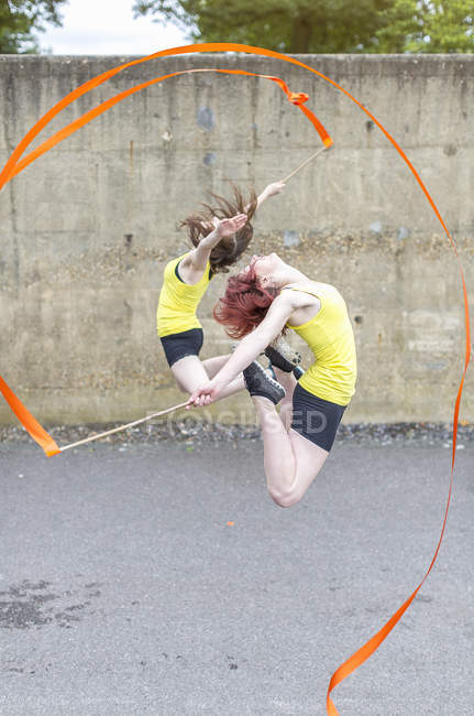 Young women practising ribbon dance on court — Stock Photo
