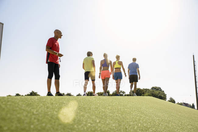 Group of people in sportswear, walking away from trainer — Stock Photo
