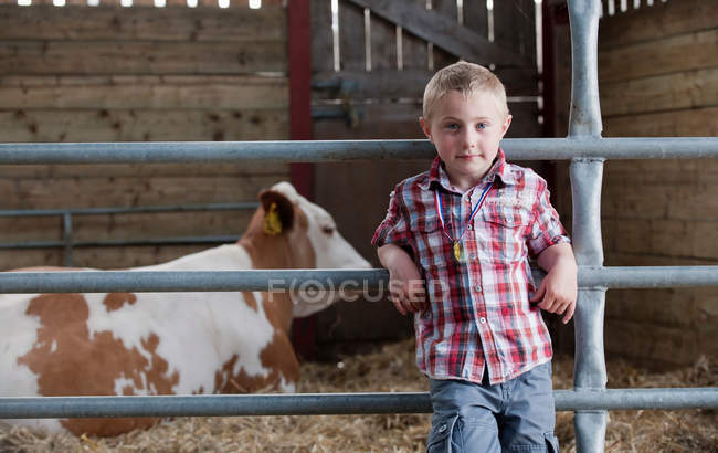 Retrato de menino no celeiro com vaca — Fotografia de Stock