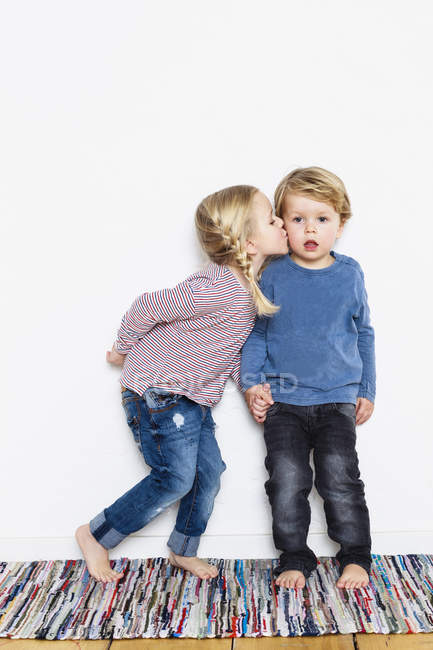 Chica joven besándose joven chico en la mejilla - foto de stock