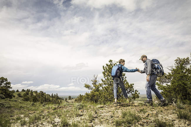 Pai e filho adolescente cumprimentando a viagem de caminhada, Cody, Wyoming, EUA — Fotografia de Stock