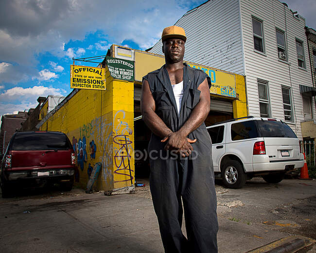 Portrait of car mechanic standing outside garage — Stock Photo