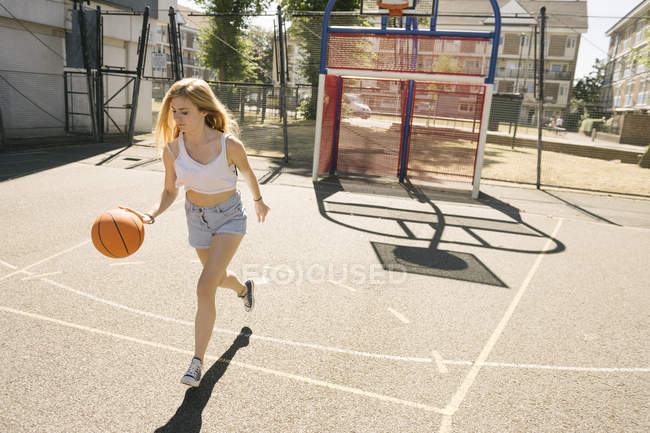 Junge erwachsene blonde Frau übt mit Basketball — Stockfoto
