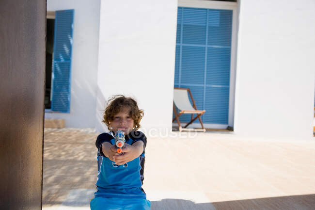 Boy holding up squirt gun — Stock Photo