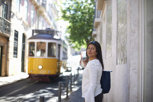Woman in street, tram in background, Lisbon, Portugal — Stock Photo