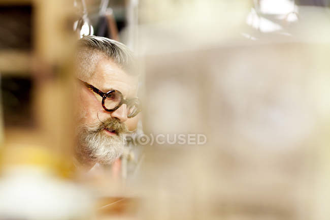 Eccentrico vintage senior man browsing in antiquariato emporio — Foto stock