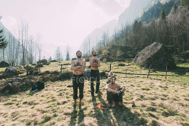Vier erwachsene Freunde beobachten männliches Bouldern aus dem Tal, Lombardei, Italien — Stockfoto