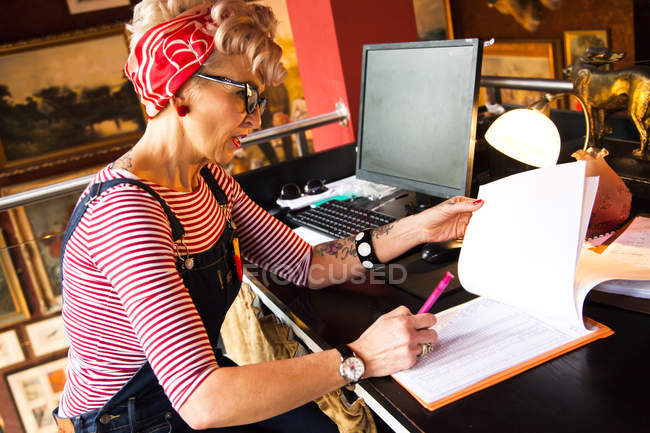 Quirky woman working at high counter at bar and restaurant, Bournemouth, England — Stock Photo