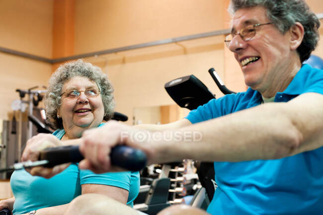 Older couple exercising in gym — Stock Photo