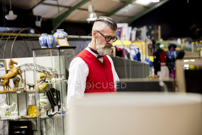 Quirky vintage senior man shopping in antiques emporium — Stock Photo