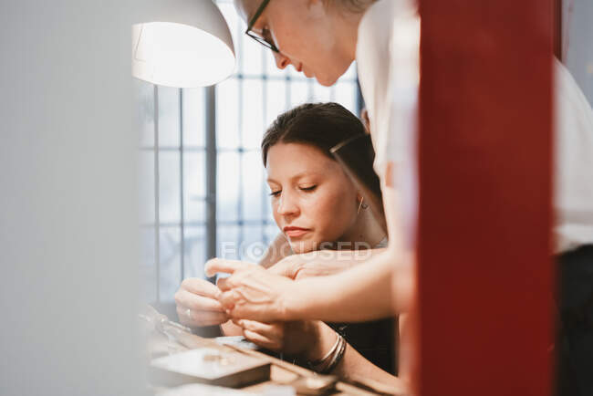 Female jewellers working with hands together at workbench — Stock Photo