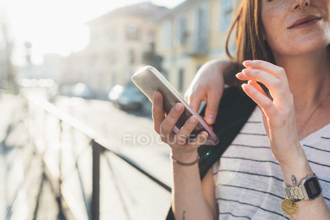 Снимок пары на тротуаре, смотрящей на смартфон — стоковое фото